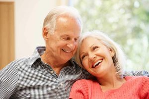 A couple sitting together, enjoying the benefits of their restorative dentistry.