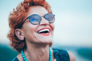 A woman smiles after her dentistry appointment. 