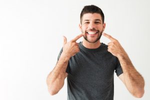 man pointing to his smile