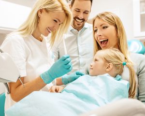 A mother holds her daughter during their routine dental exam. 