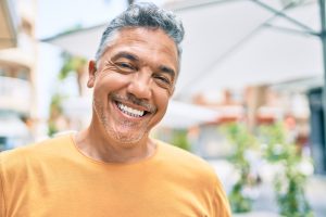 A man smiles confidently following his teeth whitening treatment.