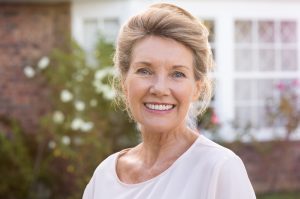 A woman smiling because her dental implants are improving her life.