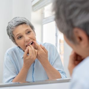 woman checking her teeth in the mirror