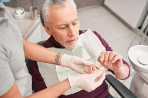 dentist showing patient a denture arch