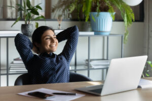 woman lounging at her desk in front of laptop