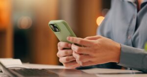 man typing on his phone at desk